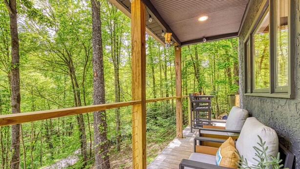 A wooden deck with a railing overlooking a forested area. - Pine and Peak – Hot Tub, Fire Pit, Dog Friendly (Gatlinburg)