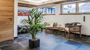 A lobby with a reception desk, a potted plant, seating area, and large windows. - 2A Morgensonne/mit Weitblick by Interhome (Bad Hofgastein)