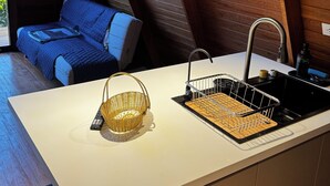 A modern kitchen with a white countertop, a built-in sink, and a hanging light fixture. - Hidden Luxury Cabin in Nature Jacuzzi, Fire Pit & Private Escape (Gobierno Regional de Lima)