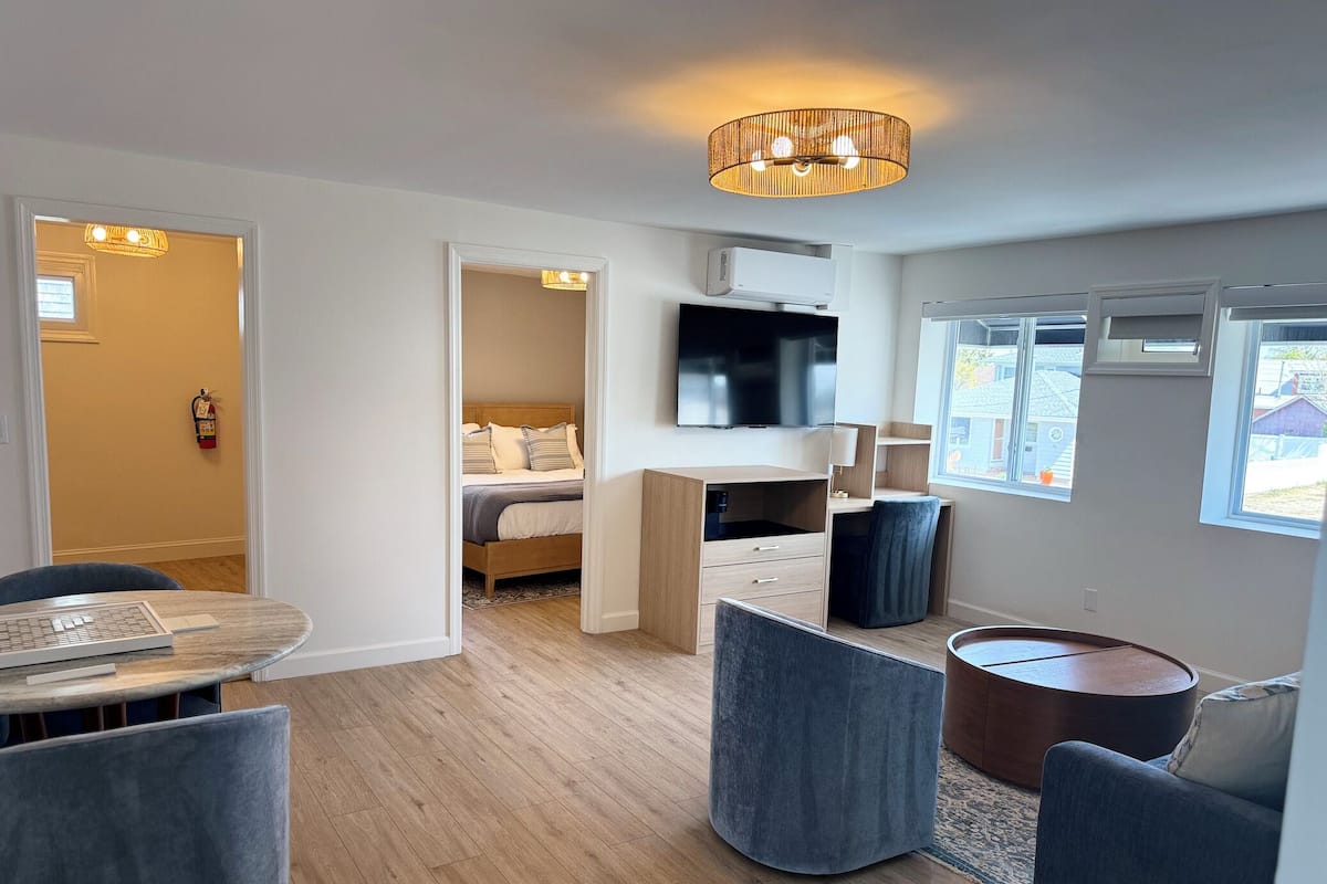 Una habitación de hotel moderna con cama, escritorio, televisión y zona de estar.