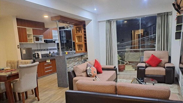 Una sala de estar moderna con comedor, cocina y un balcón con vistas.