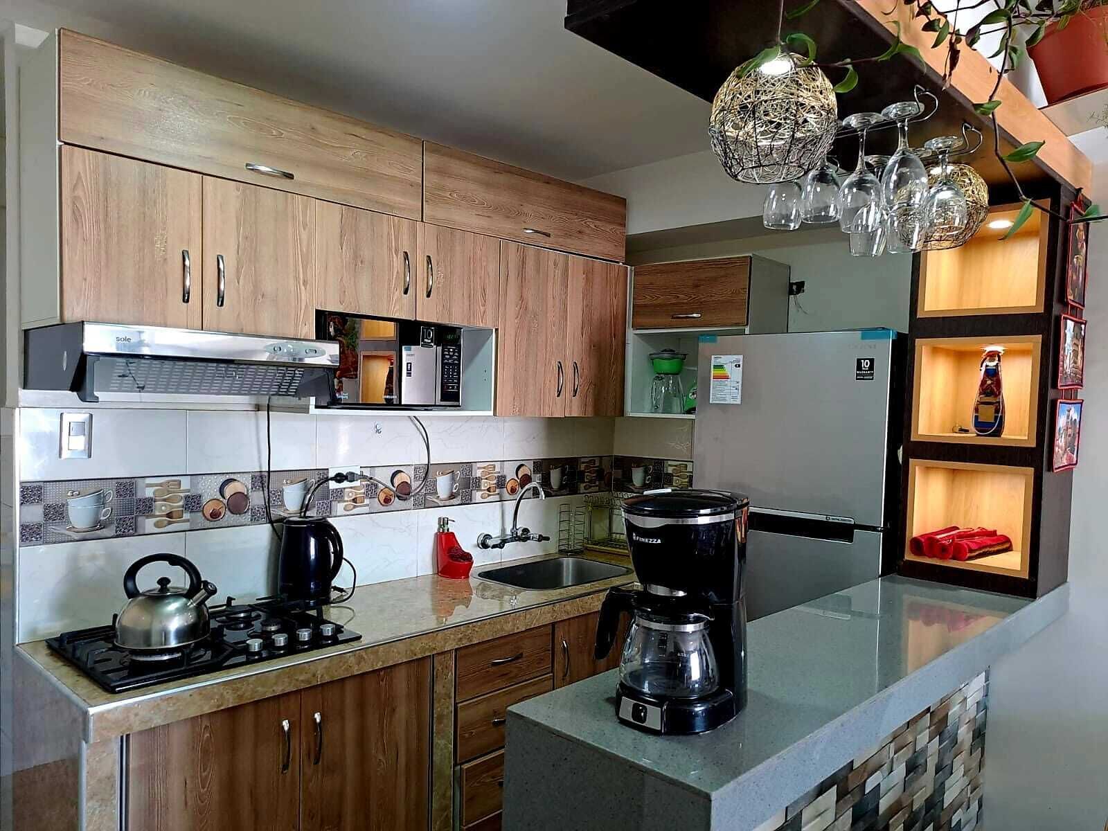 A kitchen with wooden cabinets, a gas stove, a coffee maker, and a microwave.