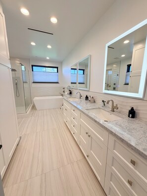 A modern bathroom with a large vanity, dual sinks, a bathtub, and a walk-in shower. - Spacious 5-bedroom house in beautiful Manhattan Beach with AC and great yards (Manhattan Beach)