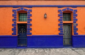 Une façade dâimmeuble avec deux portes, chacune agrĂ©mentĂ©e dâun portail en mĂ©tal dĂ©coratif et dâune petite lanterne au-dessus de la porte de droite.