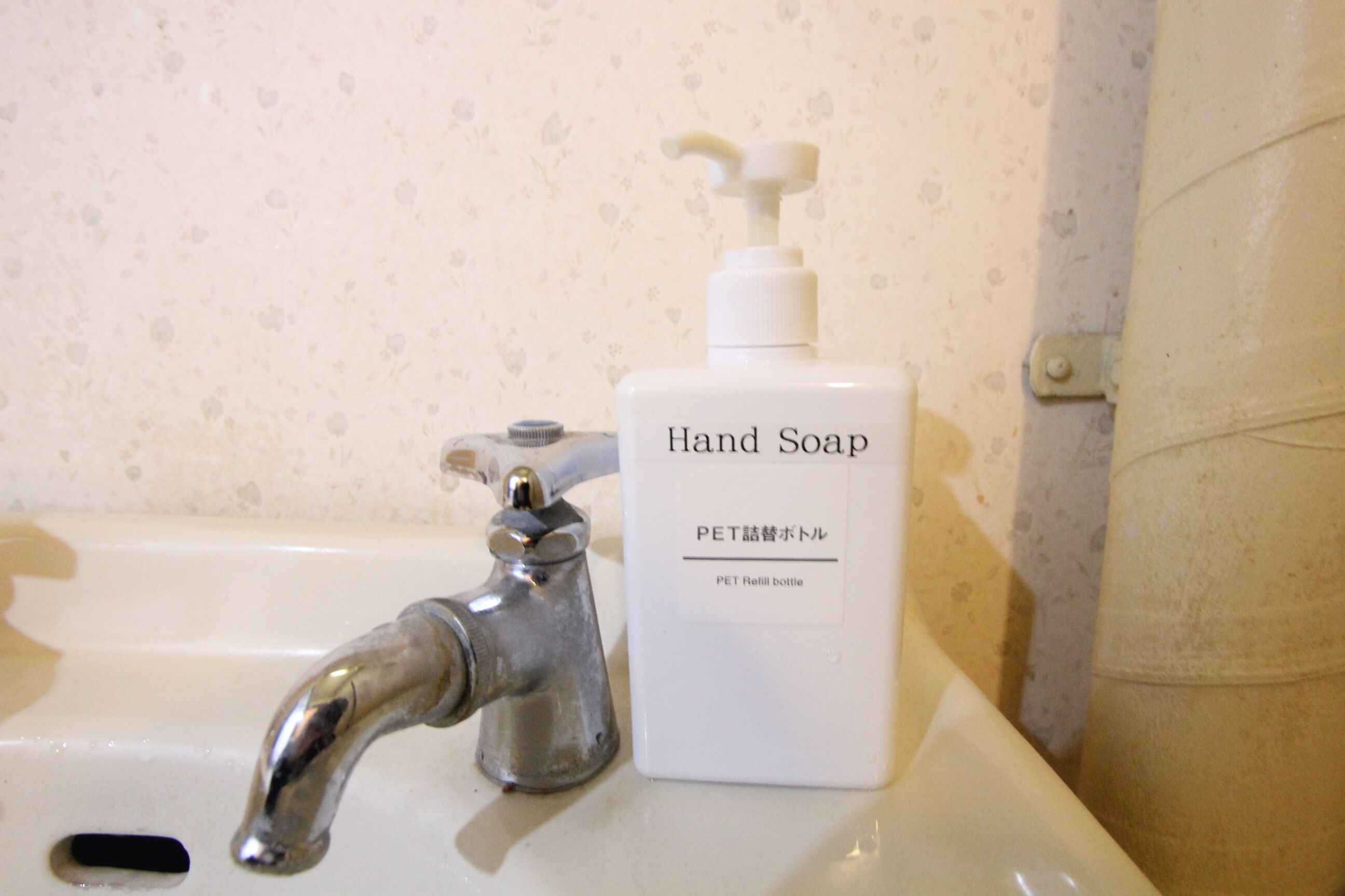 Un lavabo con dispensador de jabón y grifo.