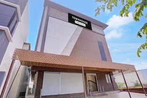 Un edificio moderno con un cartel que dice 'TOWNHOUSE' y 'oyo-Serviced'.