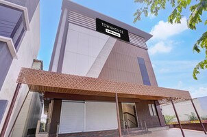 Un edificio moderno con un cartel que dice 'TOWNHOUSE' y 'oyo-Serviced'.