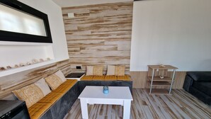 A modern living room with a sectional sofa, a coffee table, and a TV mounted on the wall.