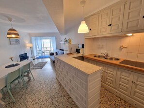 Une cuisine moderne avec des meubles blancs, un plan de travail en bois et un évier encastré.