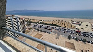A high-rise building with a view of a beach and parking lot. - APARTMENT YELLOW SEA 173 (Empuriabrava)