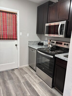 A compact kitchen with a microwave, stove, oven, and dishwasher. - Delightful 1-bedroom studio in charming Eagle Lake perfect for getaway (Susanville)