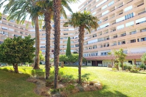 Un hôtel à plusieurs étages doté d’une cour intérieure agrémentée de palmiers et d’une pelouse.