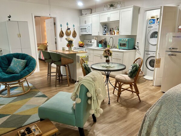 Una cucina moderna con mobili bianchi, un forno a microonde e una lavatrice.