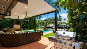 An outdoor patio with a grill, seating, and a pool. - Fox Isles Luxury Waterfront With Pool Near Beach (Fort Lauderdale)