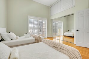 A bedroom with two beds, a large mirror, and a view of a cityscape through the window. - Toluca Lake Townhome, Central to Hollywood attractions (Los Angeles)