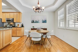Une cuisine avec des meubles en bois, un four à micro-ondes et un coin repas comprenant une table et des chaises.