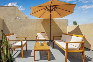 A patio with wooden furniture, a table, and an umbrella. - Toluca Lake Townhome, Central to Hollywood attractions (Los Angeles)