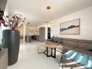 Ein modernes Wohnzimmer mit einer Couch, einem Couchtisch und einer großen Blumenvase.