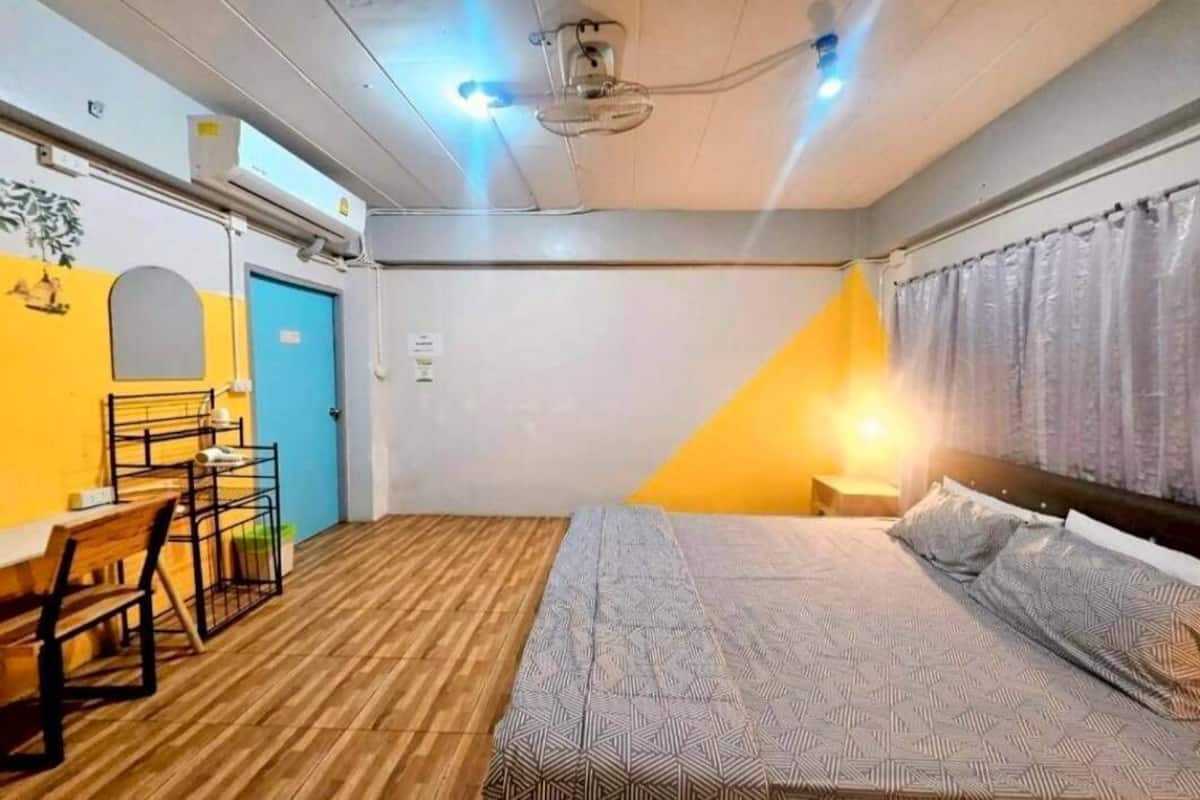 Um quarto com uma cama, uma escrivaninha e uma cadeira.
