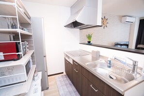 A modern kitchen with a stainless steel sink, wooden cabinets, and a built-in microwave. - 2minN.Ikebukuro,5minIkebukuro,15minShinjuku.3FL3RMhouse,WiFi,smartcheck-in.Max10 (toshimakuhoncho)