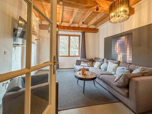 A modern living room with a sofa, a coffee table, and a large window. - Lovely house with bedrooms and ensuite bathroom. (Bernkastel-Kues)