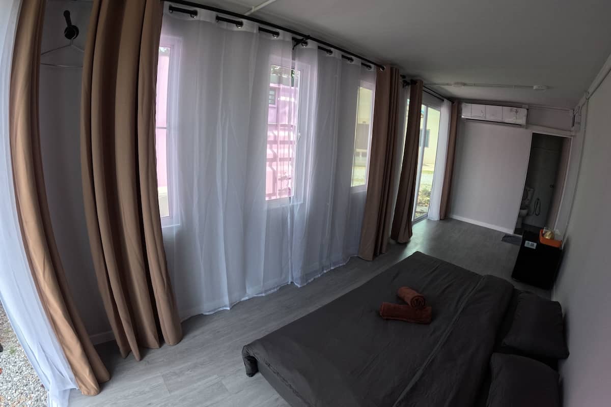 Una stanza con un letto, tende e una finestra.