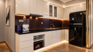 Una cocina moderna con electrodomésticos integrados, un refrigerador negro y un microondas.