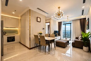 A modern living room with a dining area, a kitchen, and a balcony with a city view.