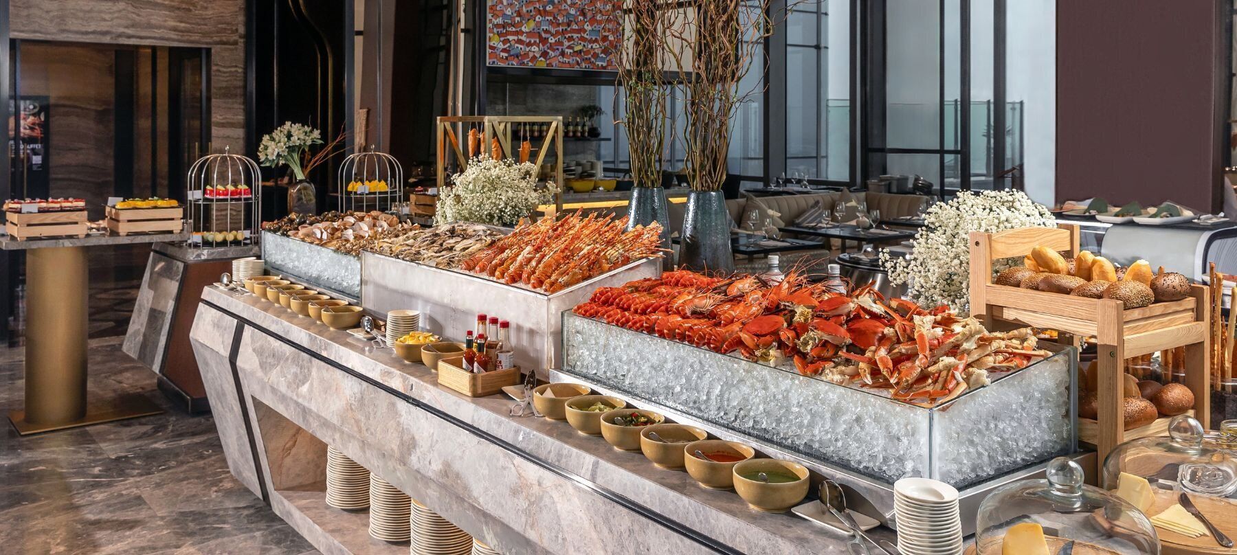 A buffet with seafood, including lobsters and crabs, and various condiments.