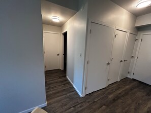 Ein Korridor mit Holzboden, weißen Wänden und einer Tür am Ende.