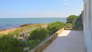 A balcony with a view of the sea and greenery. - Villa Numia A: A bright and sunny two-story independent house located right on the beach, with Free WI-FI. (Ostuni)