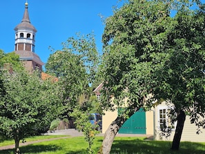 A church with a tower and a green gate in the foreground. - Aparte vacation apartment "Bi de Kark" in the historic town center (Sande)
