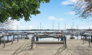 A marina with boats docked, a concrete walkway, and a clear sky. - CN Tower View -Central DT (Toronto)