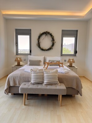 Ein Schlafzimmer mit einem Bett, zwei Nachttischen, einem Wandkranz und zwei Fenstern.
