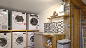 Een wasserette met meerdere wasmachines, een spoelbak en een prullenbak.