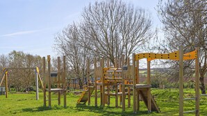 Een speeltuin met klimtoestellen en een picknicktafel.