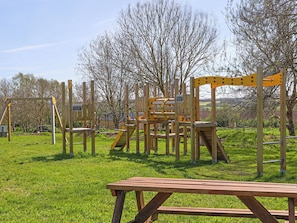 Une aire de jeux avec des structures d’escalade et une table de pique-nique.