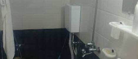 A bathroom with a toilet, sink, and shower.