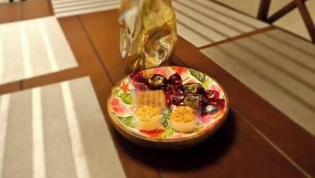 Ruokapöytä, jonka keskellä on kukkakoriste ja pöydällä on lautasellinen ruokaa.