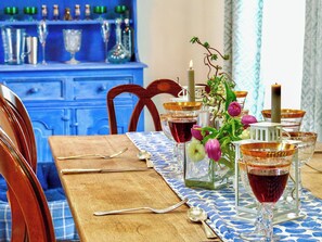 A dining table set with glasses, cutlery, and a candle.