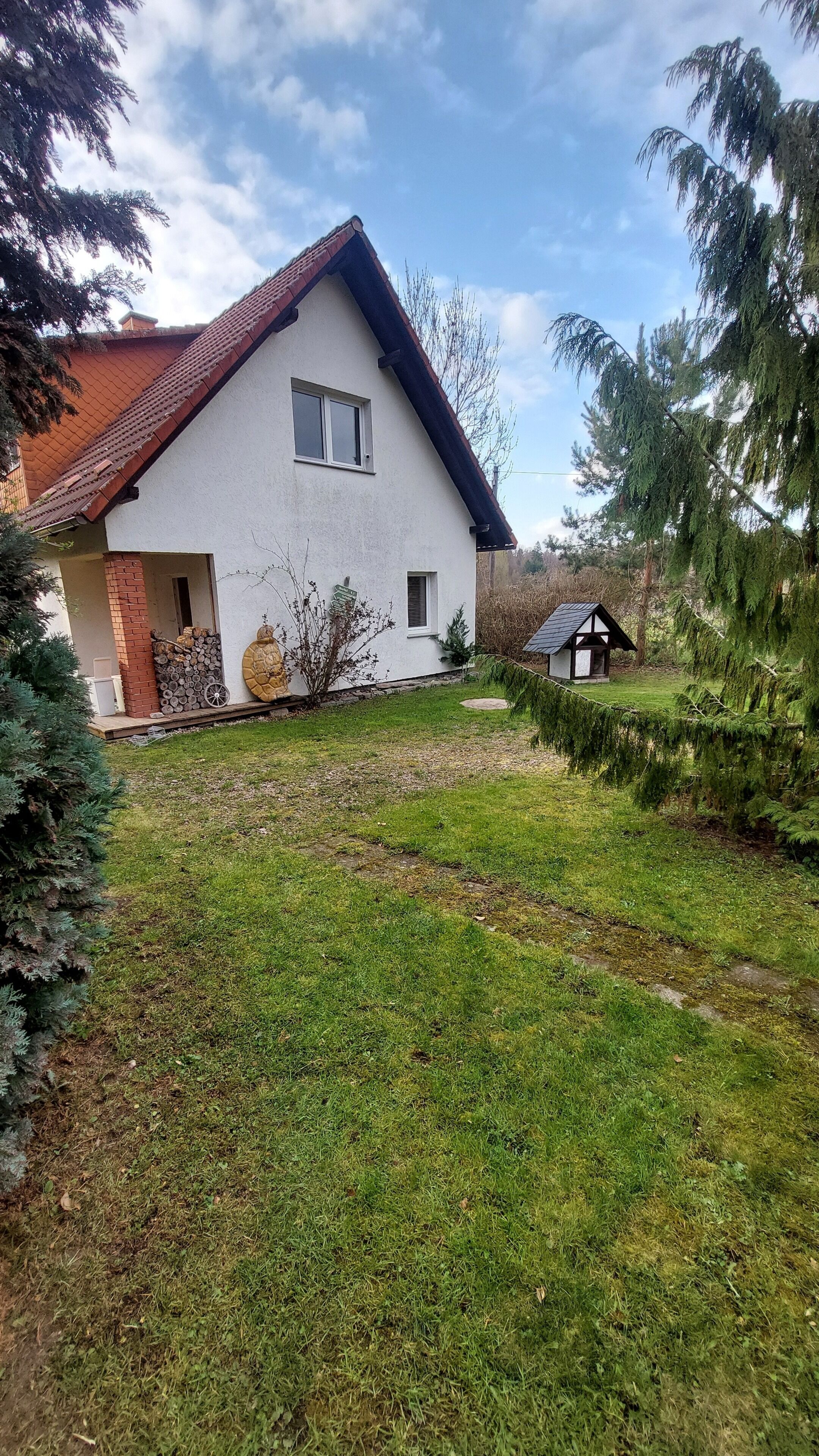 A house with a sloped roof, a small front porch, and a well-maintained lawn.