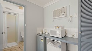 A compact kitchen with a microwave, coffee maker, and a small refrigerator. - Pacific Motel Evans Head (Evans Head)