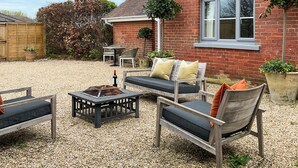 A patio with outdoor furniture, a brick building, and a window. - Elm Tree House - UK51762 (Landford, near Salisbury)