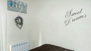 Une chambre à coucher avec un lit, un radiateur, un élément de décoration murale et une pancarte sur laquelle on peut lire : « Faites de beaux rêves ».