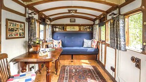 Un interior acogedor con una mesa de madera, un banco azul y un tapete estampado.