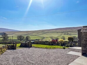 A rural landscape with a gravel driveway, stone wall, and a wooden fence. - 3 bedroom accommodation in Halton Gill (Halton Gill)