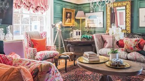 A room with a green wall, a chandelier, a sofa, a chair, a table with books, and a window with curtains. - 6 bedroom accommodation in Sandwich (Sandwich)
