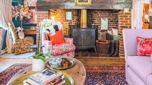 A cozy living room with a fireplace, patterned furniture, and a bookshelf. - 6 bedroom accommodation in Sandwich (Sandwich)