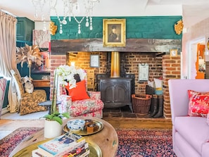 A cozy living room with a fireplace, patterned furniture, and a bookshelf. - 6 bedroom accommodation in Sandwich (Sandwich)