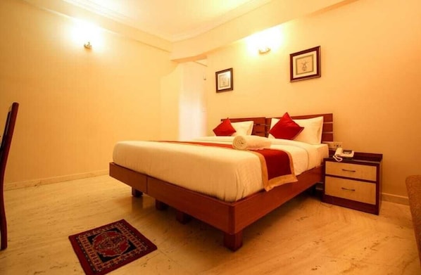 Une chambre à coucher avec un lit, une table de chevet et une commode.